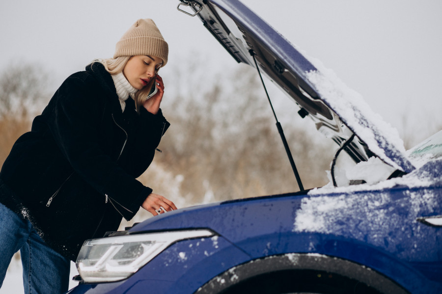 Mujer joven llamando telefono despues que su coche averio temporada invierno