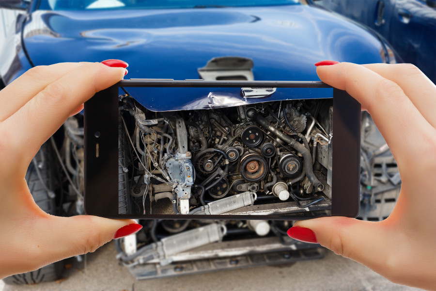 Man photographing his vehicle with damages accident insurance with smart phone