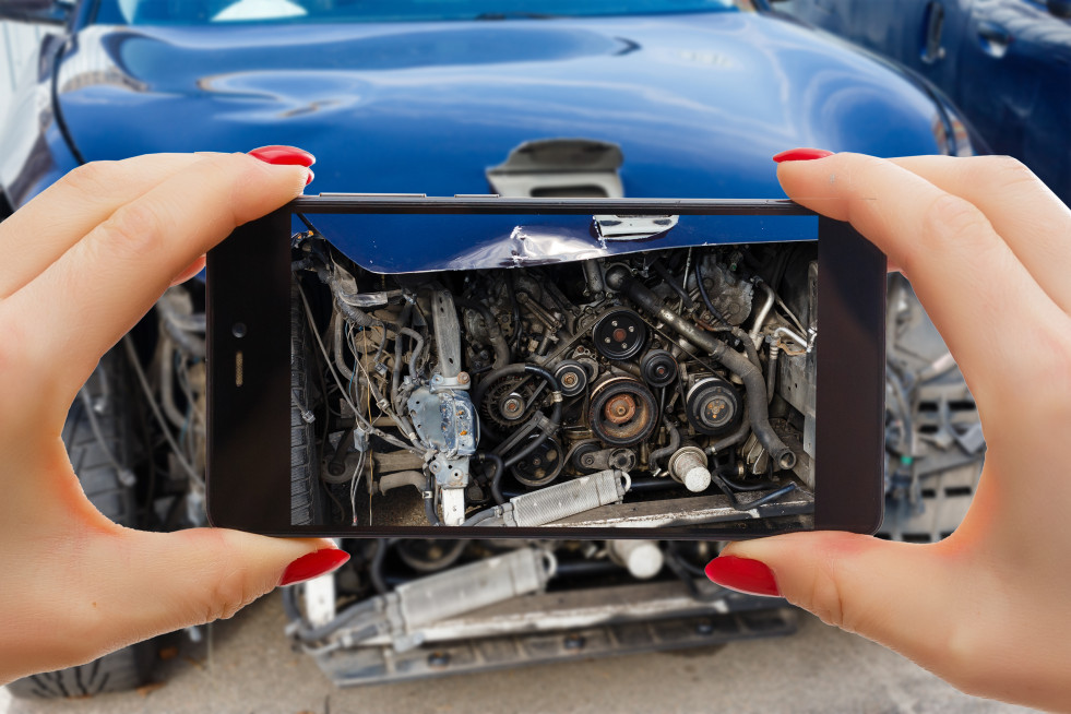 Man photographing his vehicle with damages accident insurance with smart phone